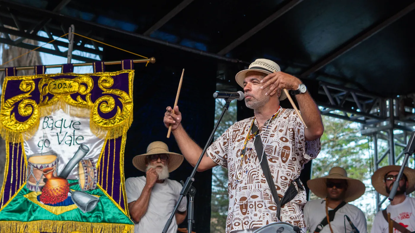 Músicos em apresentação com estandarte de Jagannatha ao fundo