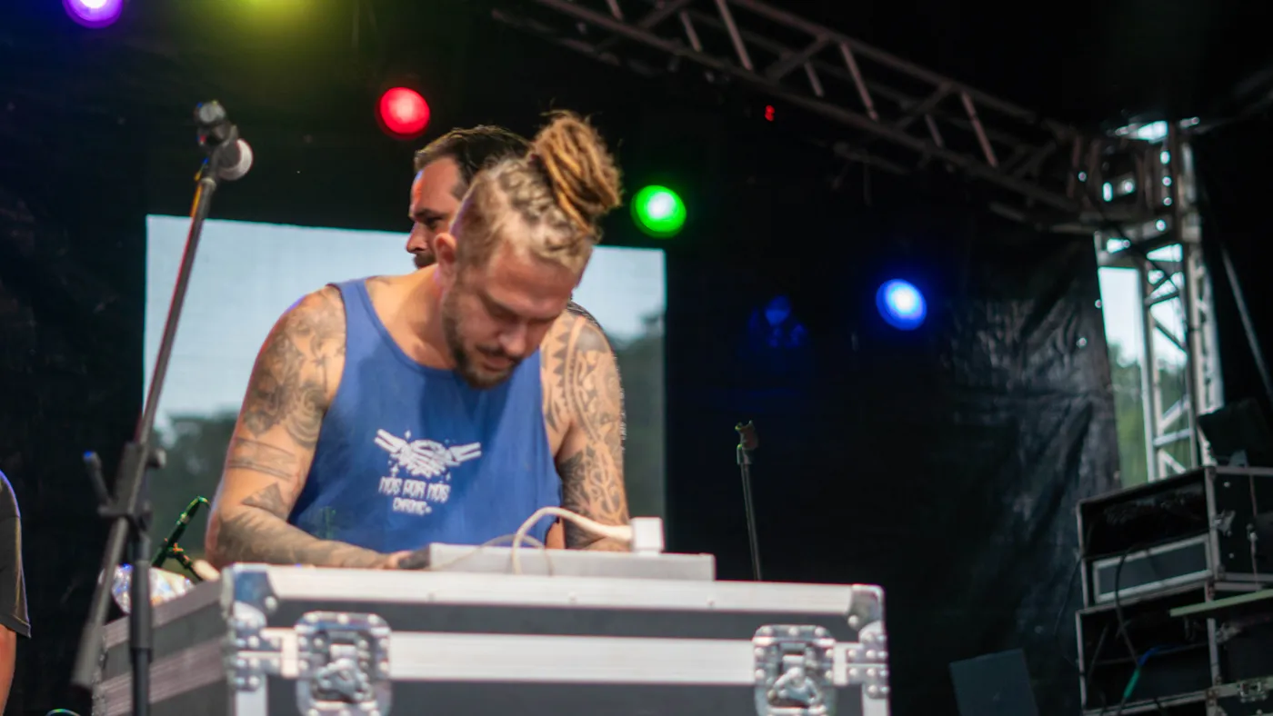 DJ se apresentando no palco com luzes coloridas