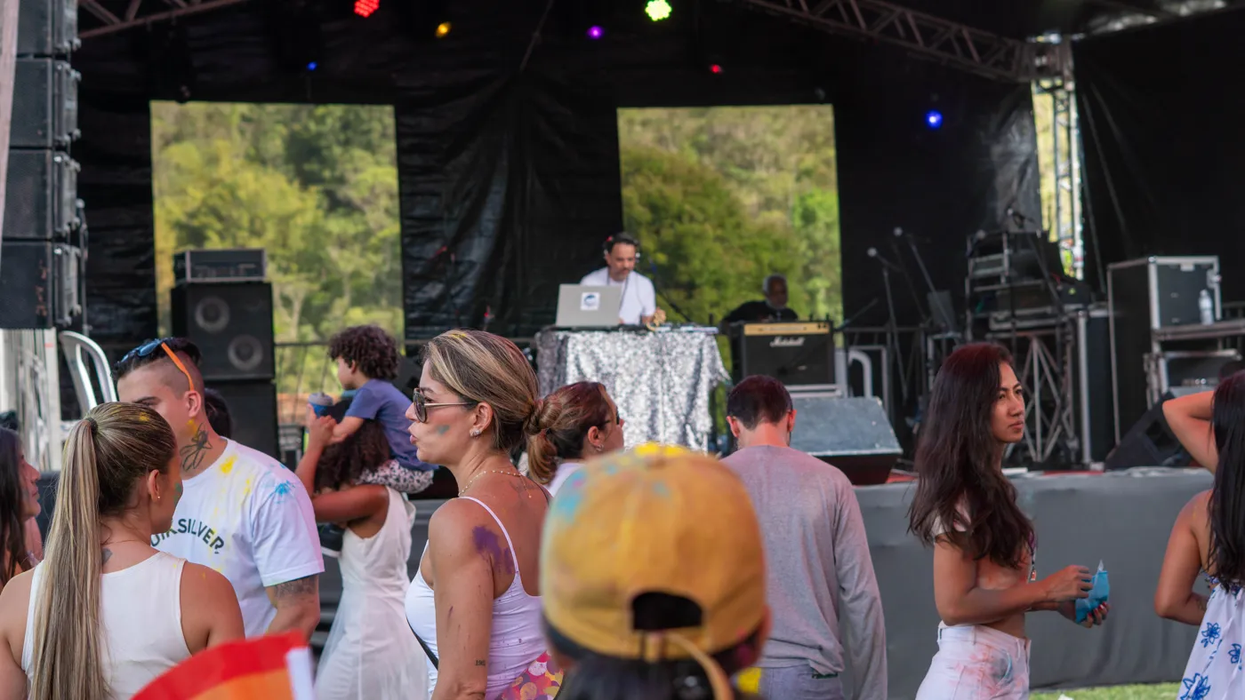 Público reunido em frente à cabine de DJ no palco ao ar livre